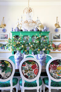 Big florals, blue and white antique vases and dishes, statement chandelier, and repurposed furniture 